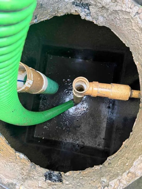 Inside the tank during pumping, with the suction hose alongside the pipework.