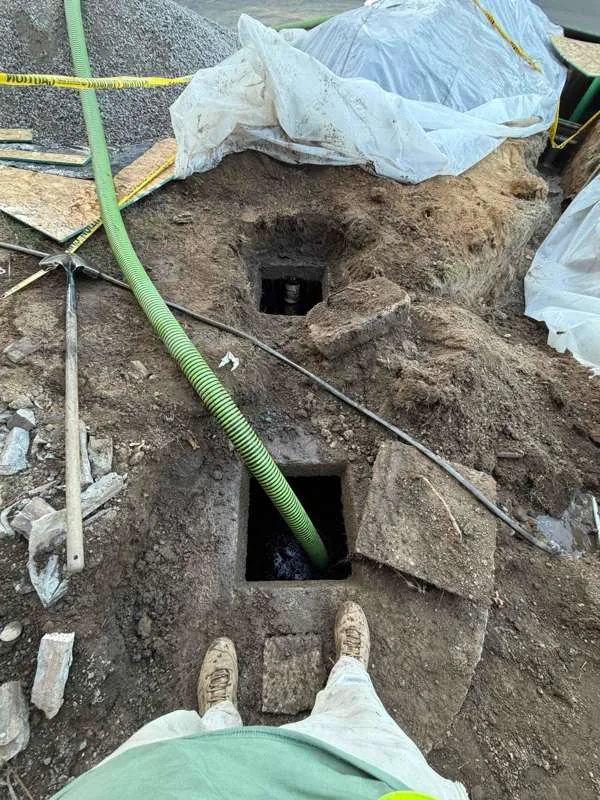 Looking down at the two openings from the technician's position, the suction hose lowered into the second compartment.