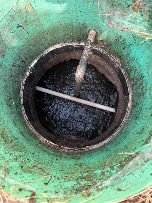The riser opened over the septic tank, looking down at the surface before pumping.