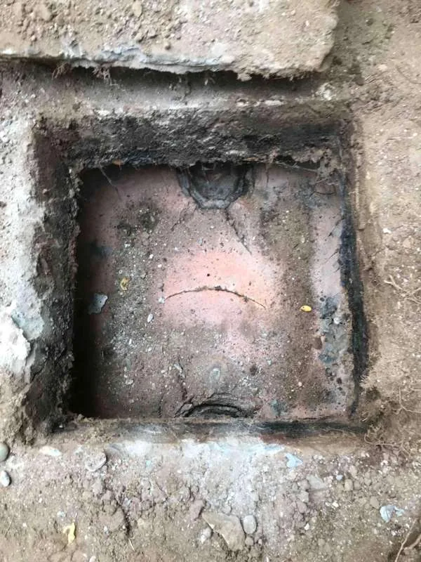 Looking down into one compartment, where much of the original floor is no longer present and soil is visible at the bottom.