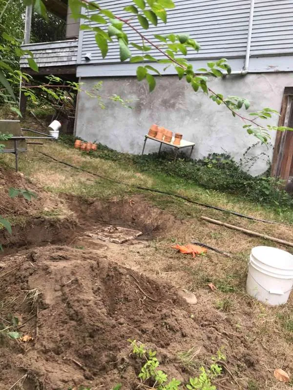 The work area looking back toward the house, with the excavation running across the garden.