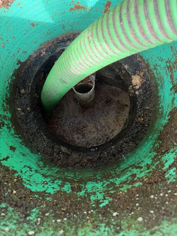 The suction hose drawing down a tank compartment through its riser.