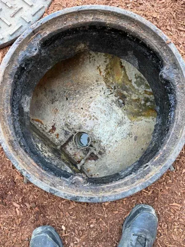 Looking down a riser at the top of the tank, with a pipe fitting visible.
