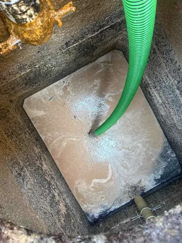 A compartment being pumped, the suction hose down through the grease layer.