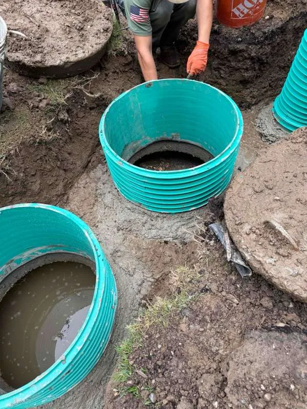 Two risers seated on the tank and packed round with fresh concrete.
