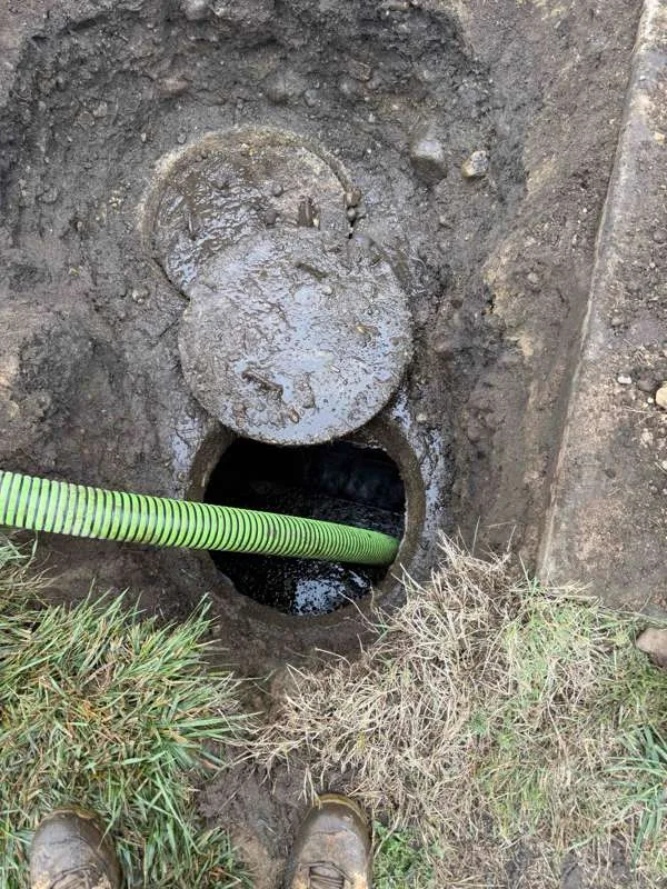 The suction hose lowered into the second compartment after it was excavated.