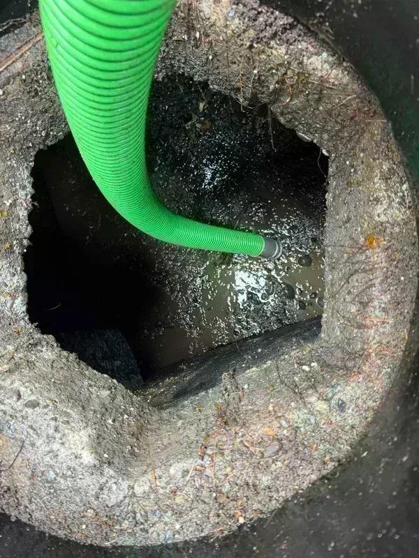 The suction hose lowered through an access opening during pumping.
