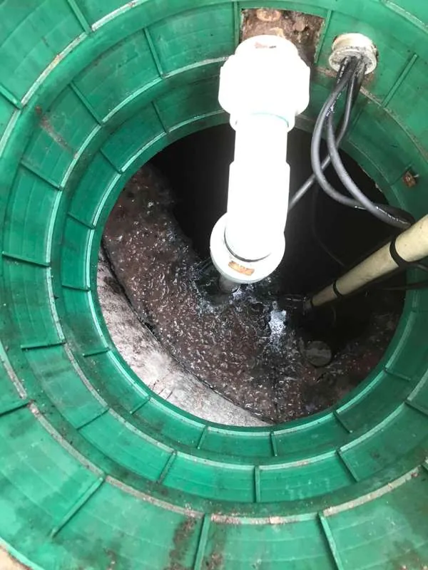 Looking down the pump tank riser at the discharge plumbing, with the liquid below churning.