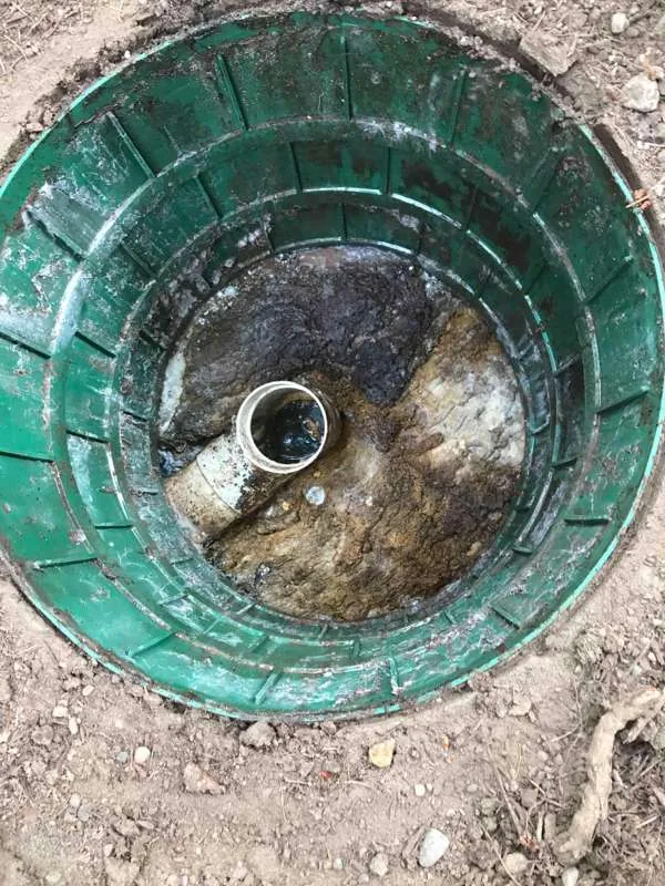 Looking down a riser at the pipe stub after pumping, the tank drawn down and the sides still coated.