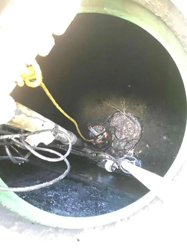 The pump and its cables at the bottom of the tank once the wastewater had been drawn down.