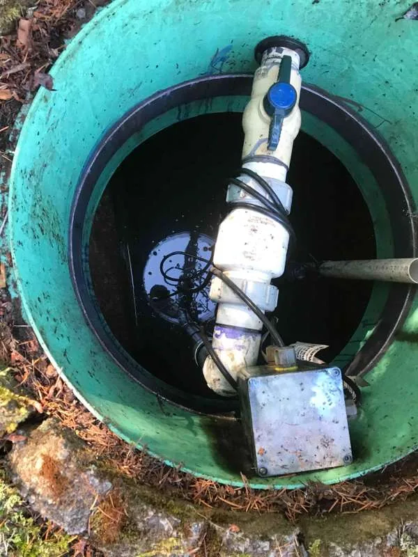Looking down the pump tank riser at the pump pipework, with a ball valve, unions and a junction box mounted on it.