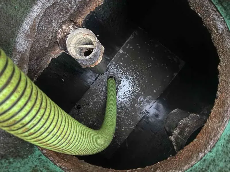The suction hose working in the tank, with the outlet filter housing set into the wall beside it.