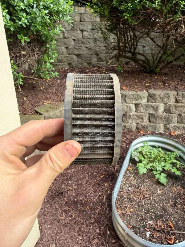 The air filter held up after cleaning, with its pleated mesh element visible.