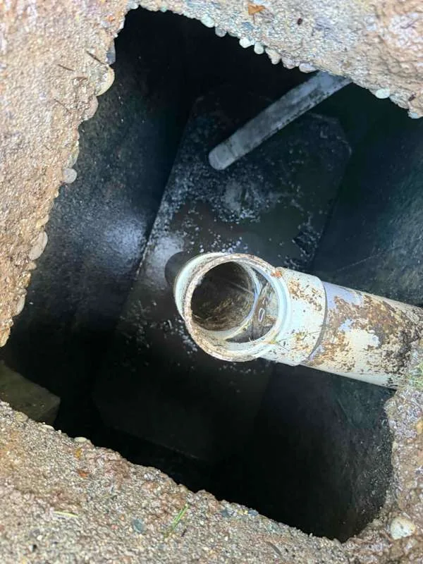 Looking into the tank at a pipe stub with the baffle behind it.