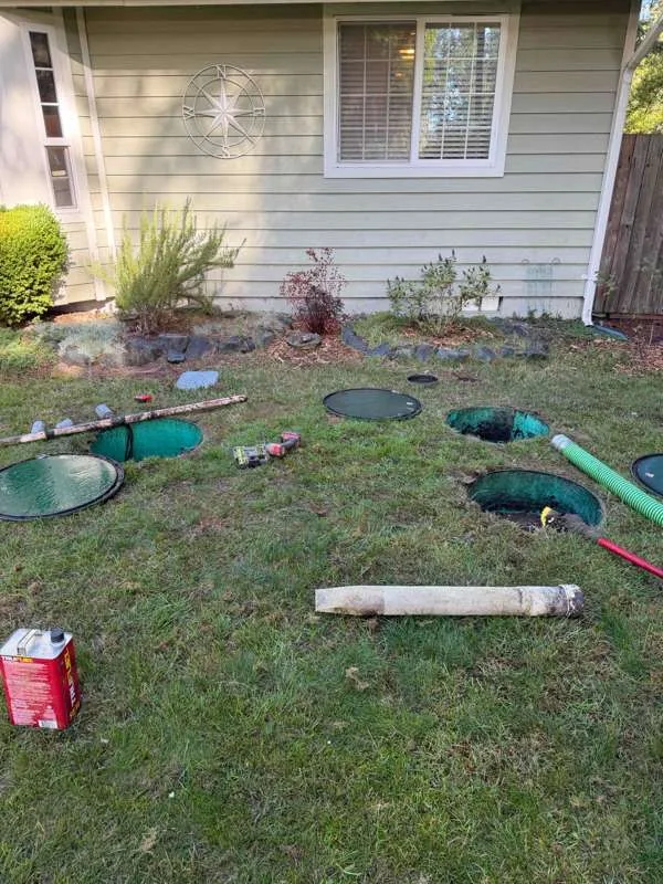 The front lawn with the risers opened, lids set aside and tools laid out between them.