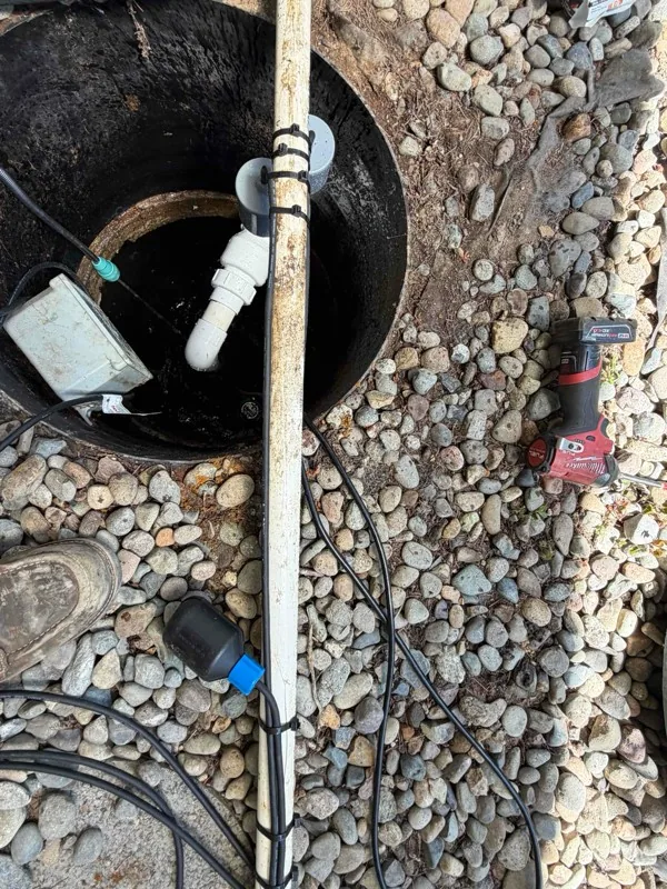 The new discharge piping and the float set on their pole, going down into the tank opening.