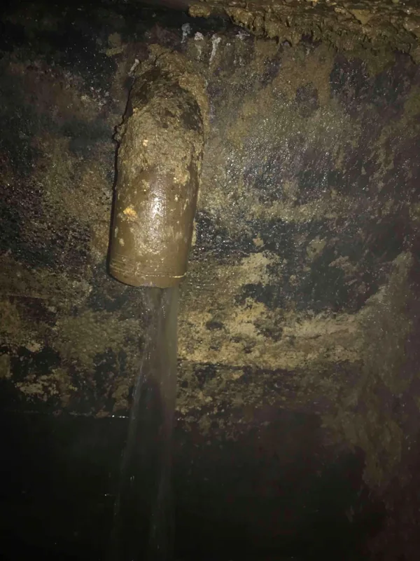 Liquid running into the tank from a pipe in the wall.