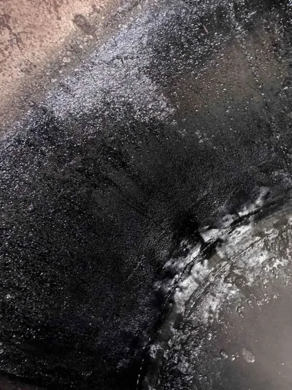A close-up inside the tank, with scum built up against the wall.