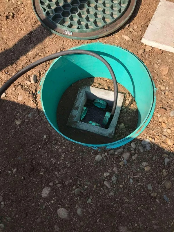 The riser over the distribution box, with a hose run down into it.