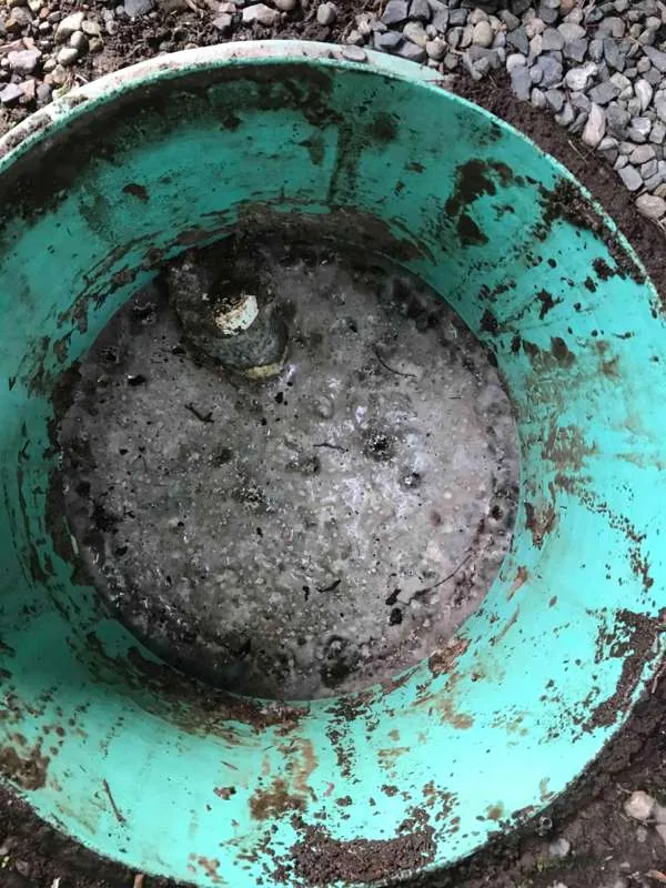 Looking down a riser at the lid below, with its retaining bolt standing proud.
